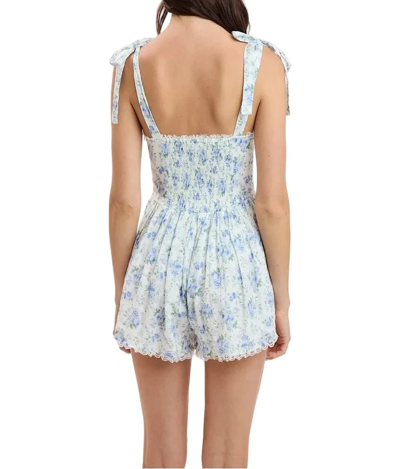 Light blue floral romper, open back with tied shoulder straps and lace-trim shorts
