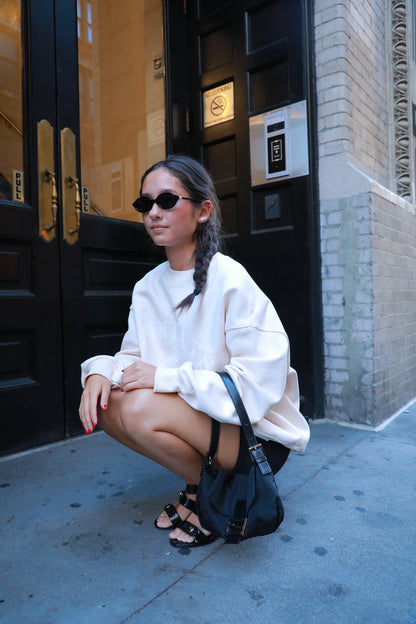 White crewneck sweatshirt with relaxed fit and logo graphic on chest
