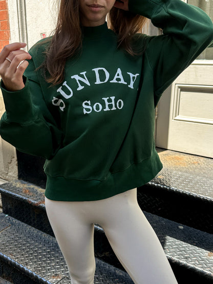 Dark green crewneck sweatshirt with white “Sunday SoHo” arched lettering